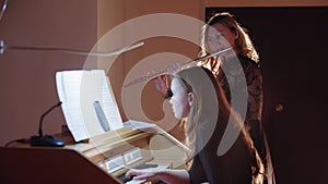 Music rehearsal - female flutist and organist playing music in church