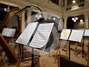 Music score with notes in hall of the conservatory at classical music concert