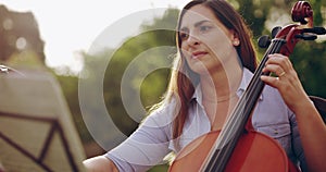 Music, sheet music and a woman playing the cello outdoor in a garden with her orchestra or choir. Art, creative and