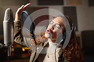 Music, singing and black woman recording in studio in home, streaming with microphone, headphones and talent. Technology