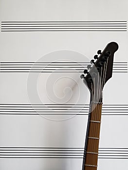 background musical theme with a toy electric guitar and a sheet with lines for musical notes