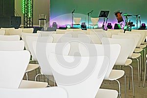 music stage before performance with white chairs.