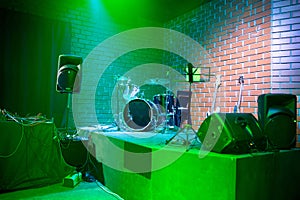 Music stands, microphones, musical instruments and chairs at a concert stage