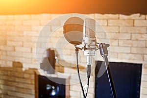 Music studio. Silver condenser microphone with pop filter