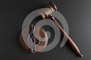 Music symbol treble clef and judge gavel on black background. Music copyright infringement. Music piracy