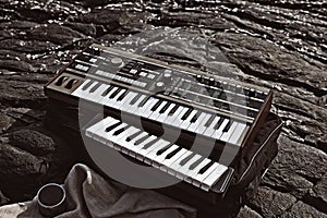 Music synthesizer lying on rocks