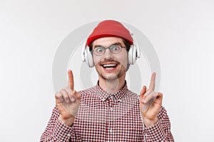 Music, technology and people concept. Groovie cute bearded man in glasses and red beanie, dancing joyfully to cool song