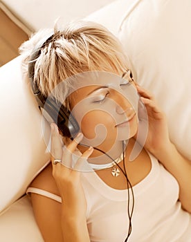 Music - Woman in living room listening to MP3 player smiling