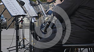 Musical band playing on oboe outdoor. Male musician play music on wind instrument while street performance. Outdoor