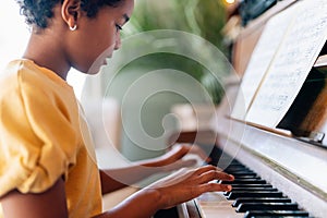 Musical education. Happy black girl playing the piano
