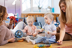 Musical education for preschoolers. Parents play musical toys with their children