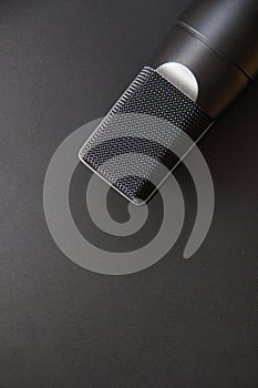 Musical equipment, Professional condenser studio microphone, dark color. Close up from above