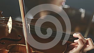 Musical group performs on stage close up of the violin. Black smoke background