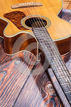 Close up of acoustic guitar. Acoustic guitar against an old wooden background