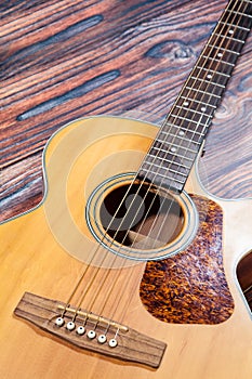 Close up of acoustic guitar. Acoustic guitar against an old wooden background