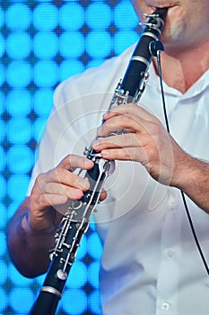 Musical instrument flute in the hands of a male musician.