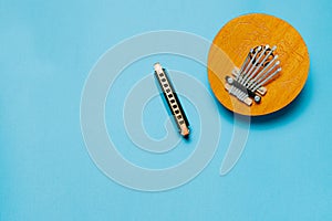 musical instrument kalimba and harmonica on a blue background. flat lay