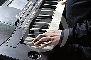 Man plays the piano with his hands.