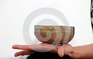 Musical instrument - singing Himalayan bowl. The singing bell holds the girl in his hand. The practice of healing vibrations,