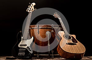 musical instruments, bass drum barrel acoustic guitar and bass guitar on a black background