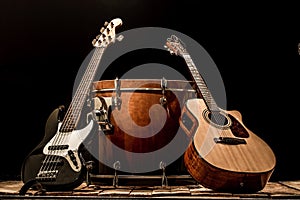 musical instruments, bass drum barrel acoustic guitar and bass guitar on a black background