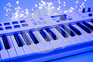 Musical keys and a garland on a blurred background with neon lighting.