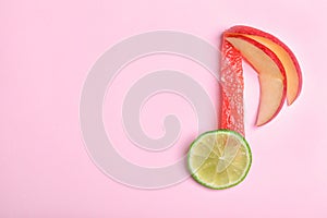 Musical note made of fruits on color background, top view