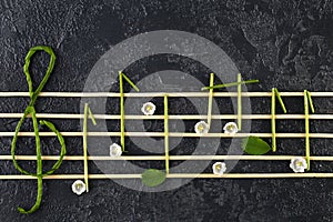 Musical notes conception. Wooden musical notes and flowers