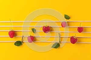 Musical notes conception. Wooden musical notes and raspberries