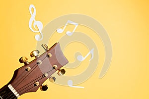 Musical notes and guitar fretboard close up, flat lay on yellow background. Music backdrop