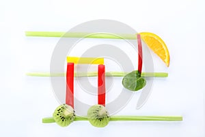 Musical notes made of fruits and vegetables on white background