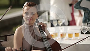 Musical quartet. Girl playing cello in a quartet of violinists. Medium shot.
