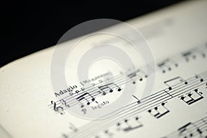 Musical tempo `Adagio` in an old music notebook photo