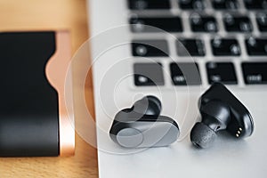 Musical wireless headphones on a gray background with a large bludgeon.