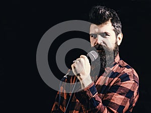 Musician with beard lighted by spotlight, copy space. Musician, singer makes effort to win musical contest. Talent show