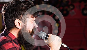 Musician with beard and mustache singing song in karaoke. Punk rock concept. Guy likes to sing in aggressive manner. Man