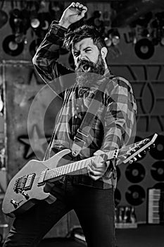 Musician with beard play electric guitar. Man with enthusiastic face