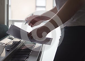 Musician brainstorming and innovating new song ideas at piano