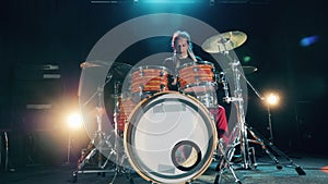 A musician with dreadlocks is playing drums. Male Drummer playing drums in smoke.