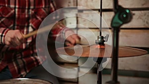 Musician with drumsticks playing drums and cymbals