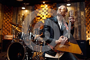 Musician in glasses playing the balalaika