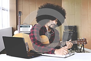 Musician with hands in guitar inside recording studio