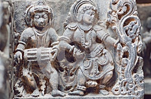 Musician with indian drum and lady dancing in traditional style. Stone relief of the 12th century Hindu temple