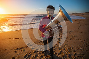 Musician instrumentalist playing the Tuba on the sea coast. Hobby.