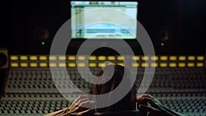 Musician listening music indoor. Sound producer working in recording studio.