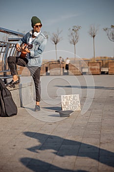 Musician looking at a hat on the ground