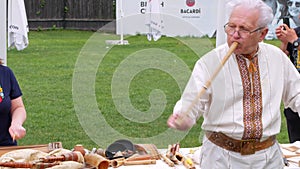 Musician man plying sopilka rebro ethnic woodwind musical instrument. Pan flute music festival Lviv, Ukraine May 14 2022