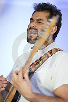 Musician passionately singing and playing guitar