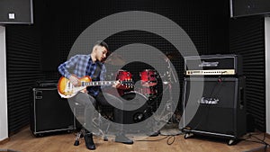 Musician is performing love lyric song on electric guitar on stage at sound recording studio. Professional guitarist is playing ro