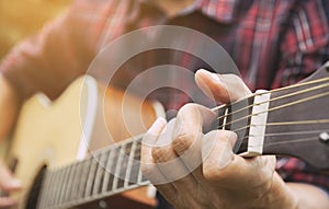 Musician playing acoustic guitar. Close up of man hand playing guitar